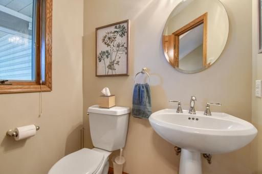 Convenient main-level half bath featuring a pedestal sink and neutral finishes.