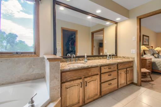 Spacious primary bath featuring a large vanity, abundant cabinetry, and direct access to the bedroom.