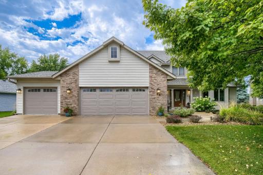Beautifully landscaped front yard with mature greenery and an inviting covered entry.