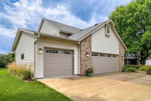 Attractive two-story home featuring a three-car garage, brick accents, and welcoming curb appeal.