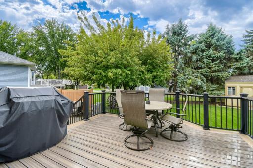 Spacious deck overlooking the beautifully maintained backyard, offering a great space for outdoor dining, grilling, and relaxing.