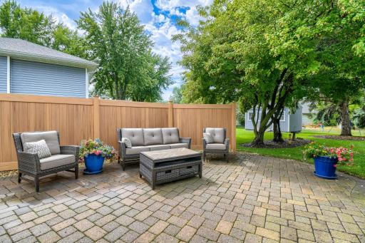 Private paver patio surrounded by attractive landscaping and a privacy fence for a peaceful outdoor retreat.