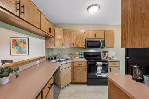Plenty of cabinet and counter space makes meal prep easy, with a pass-through to the dining area, new flooring, a brand-new microwave and a stove, refrigerator and dishwasher replaced around 2019.