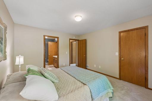 A second view of the primary bedroom, showing the doors from left to right to the bathroom, the hallway, and the large closet.