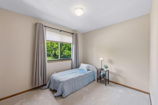 Afternoon sunshine and a leafy outlook brighten the second bedroomâa welcoming space for guests, a home office or everyday rest, with fresh paint and new carpet.