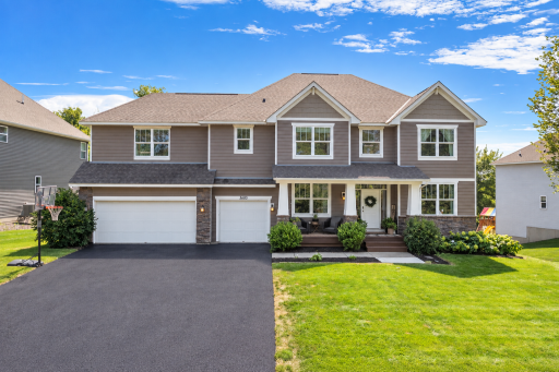 Beautiful curb appeal with a three-car garage, covered front porch, attractive landscaping, and freshly resealed driveway.