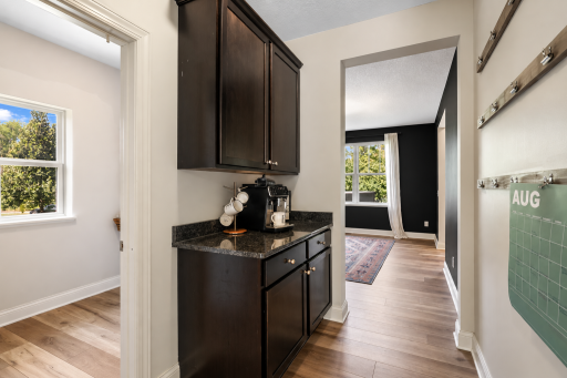 A convenient transition space featuring built-in cabinetry, granite countertop, and a dedicated coffee station.