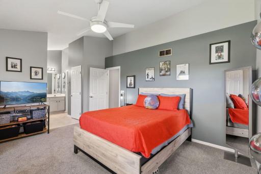 Primary bedroom has vaulted ceiling, ceiling fan and newer carpet.