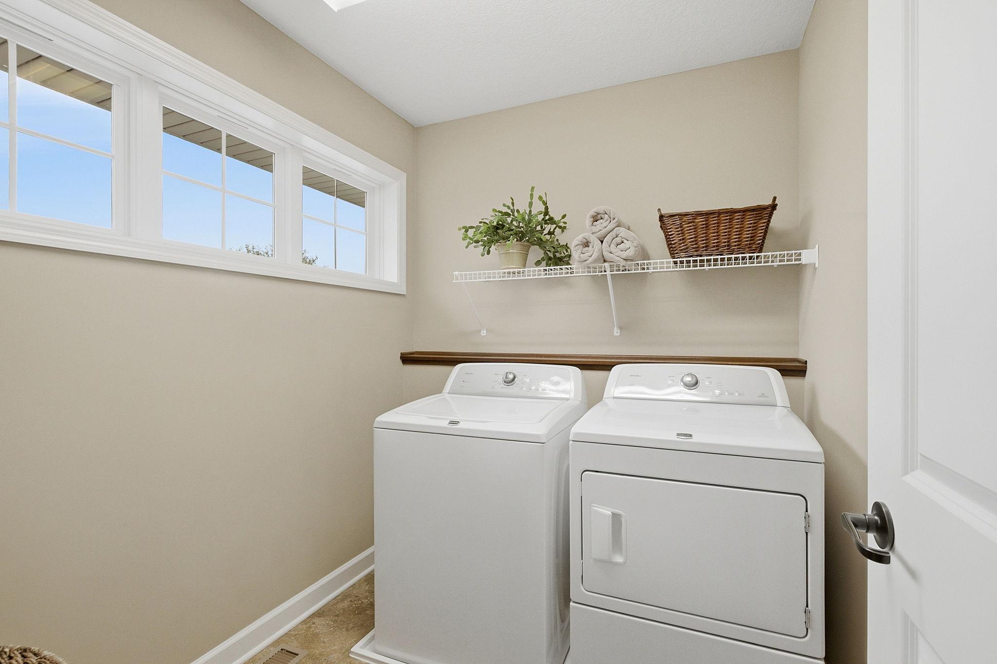 Convenient upper level laundry with large window for natural light as well as utility shelf and spacious layout.
