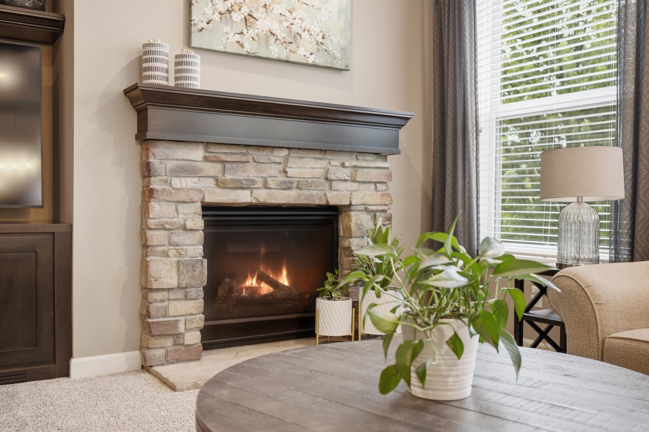 Focal stone surround gas fireplace with wood mantle