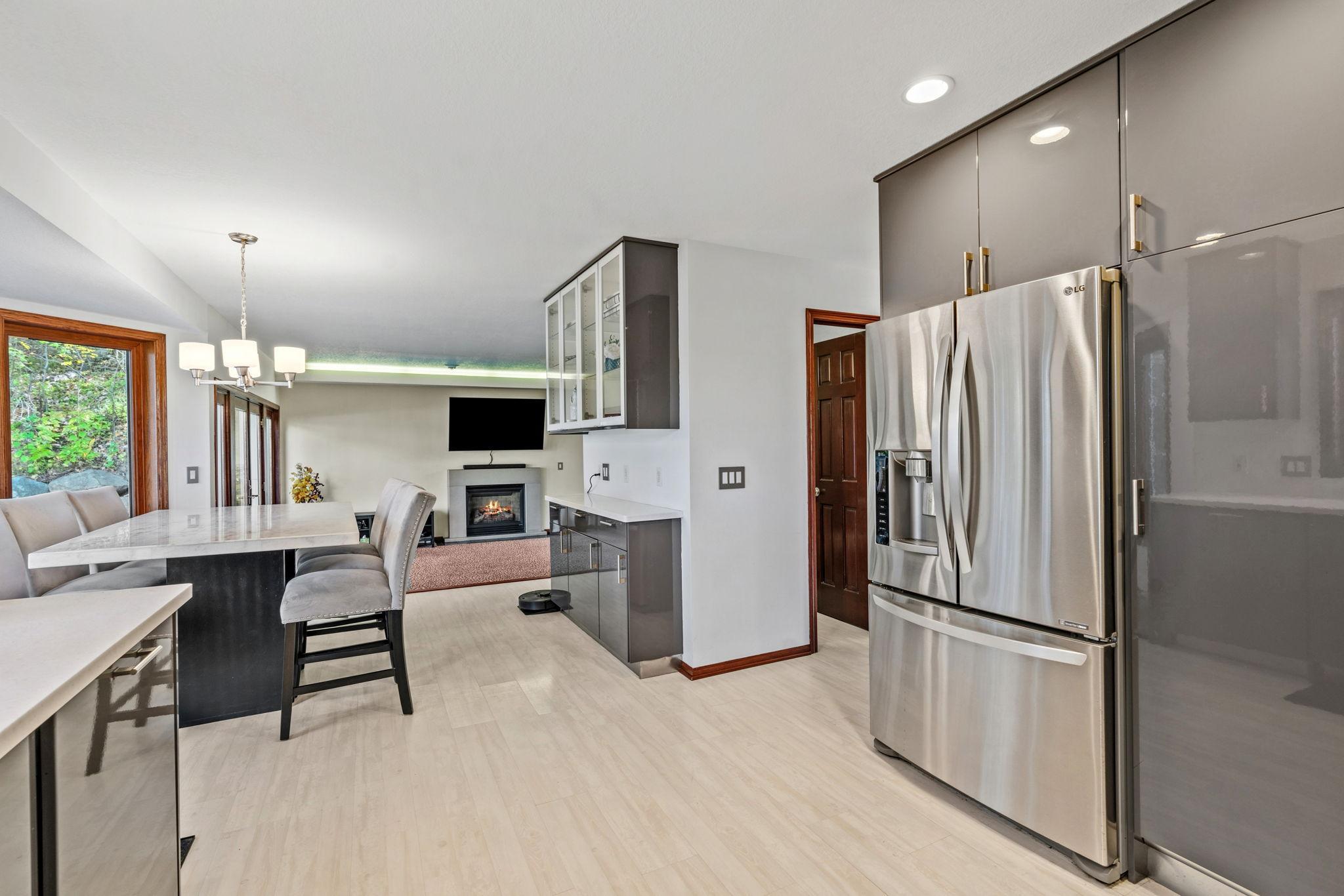 The kitchen features gray IKEA cabinetry, resin countertops, a built-in glass hutch, and stainless-steel appliances.