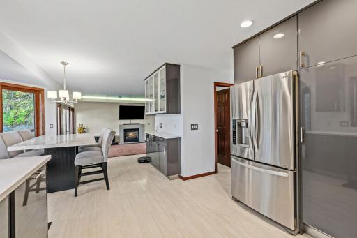 The kitchen features gray IKEA cabinetry, resin countertops, a built-in glass hutch, and stainless-steel appliances.