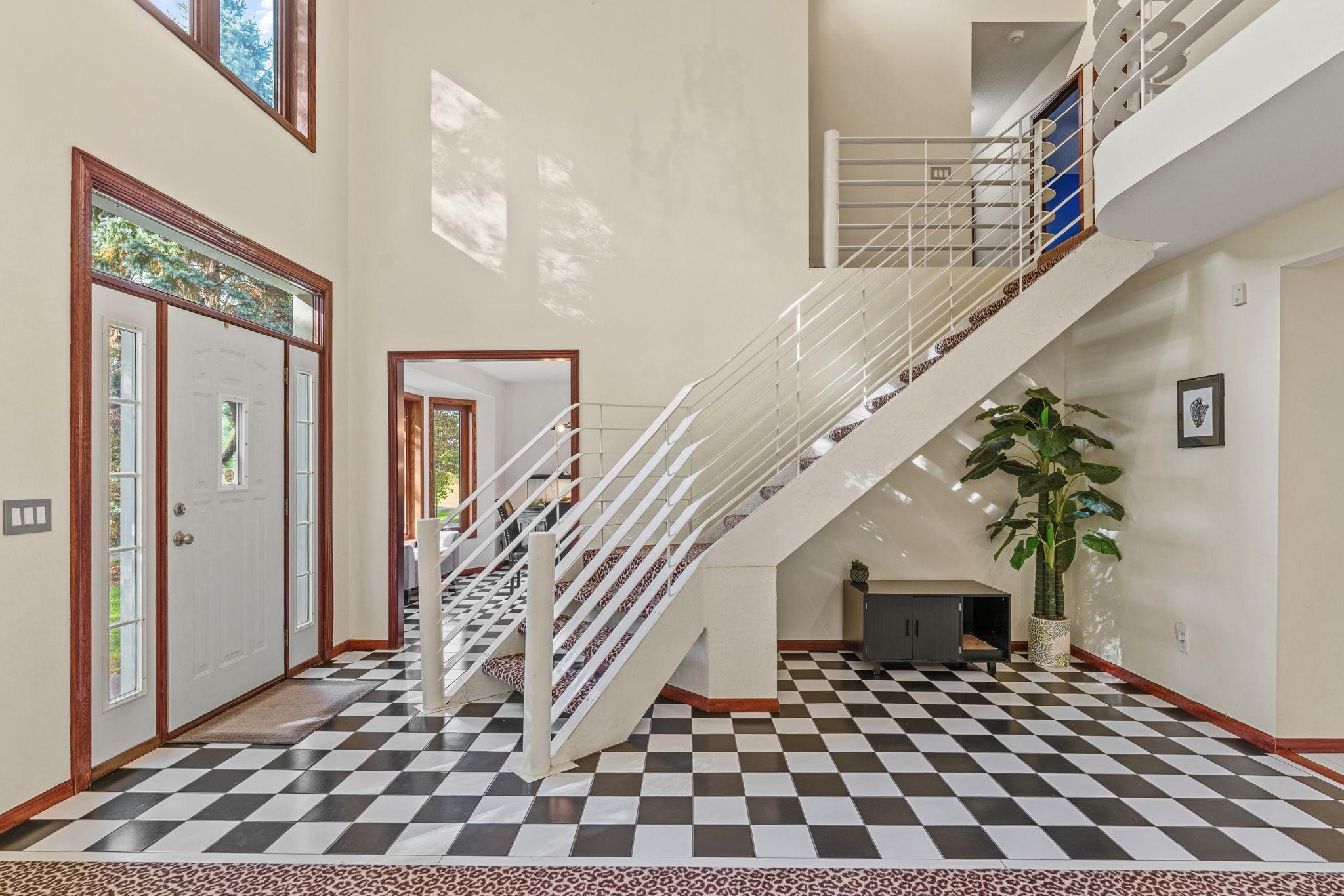 Step inside to this WOW FACTOR of a Foyer complete with a Contemporary Staircase and 2 Story Vaulted Ceilings!