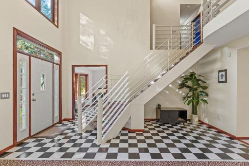 Step inside to this WOW FACTOR of a Foyer complete with a Contemporary Staircase and 2 Story Vaulted Ceilings!