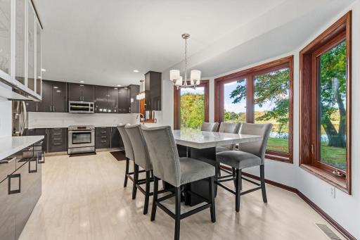 The kitchen features gray IKEA cabinetry, resin countertops, a built-in glass hutch, and stainless-steel appliances.
