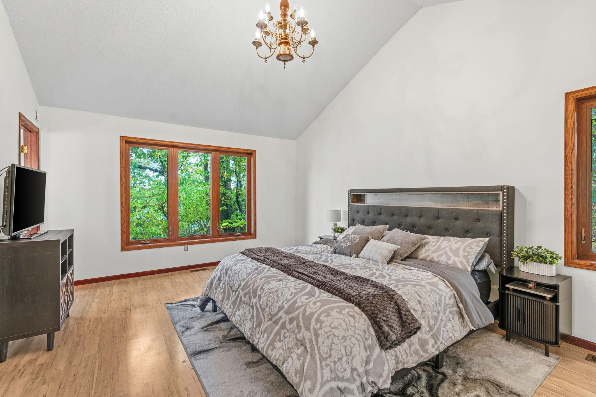 The spacious primary suite showcases vaulted ceilings, a 3/4 On-suite bath with glass incased shower, a walk-in closet and beautiful views of the water from EVERY window.
