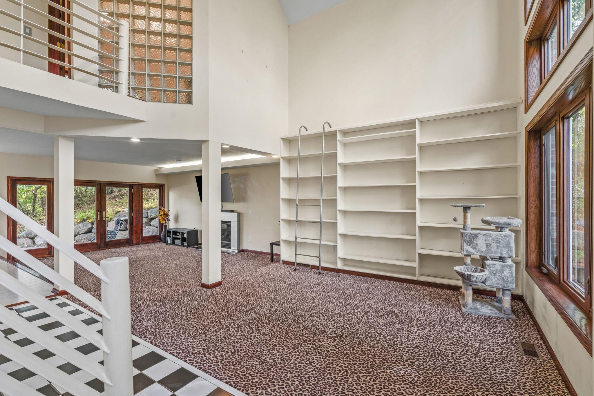 A Decorative Wall Book Case with 2 Story Windows and a Gas Fireplace complete the COZY 2 Level, Family Room filled with Natural Light!