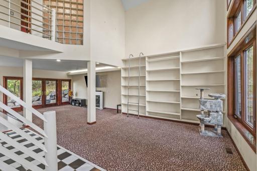 A Decorative Wall Book Case with 2 Story Windows and a Gas Fireplace complete the COZY 2 Level, Family Room filled with Natural Light!