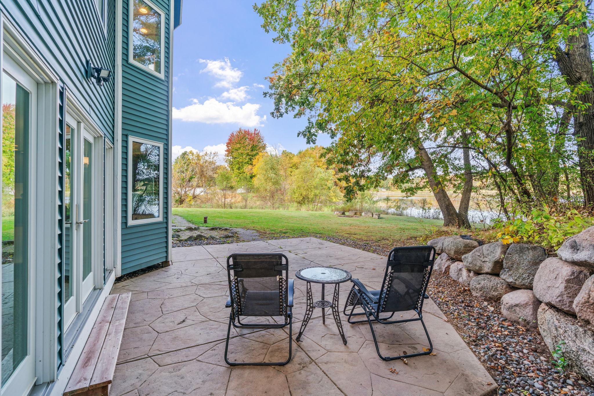 Enjoy 2 full acres of privacy, mature trees, a dock, fire pit, patio, and peaceful views of the water