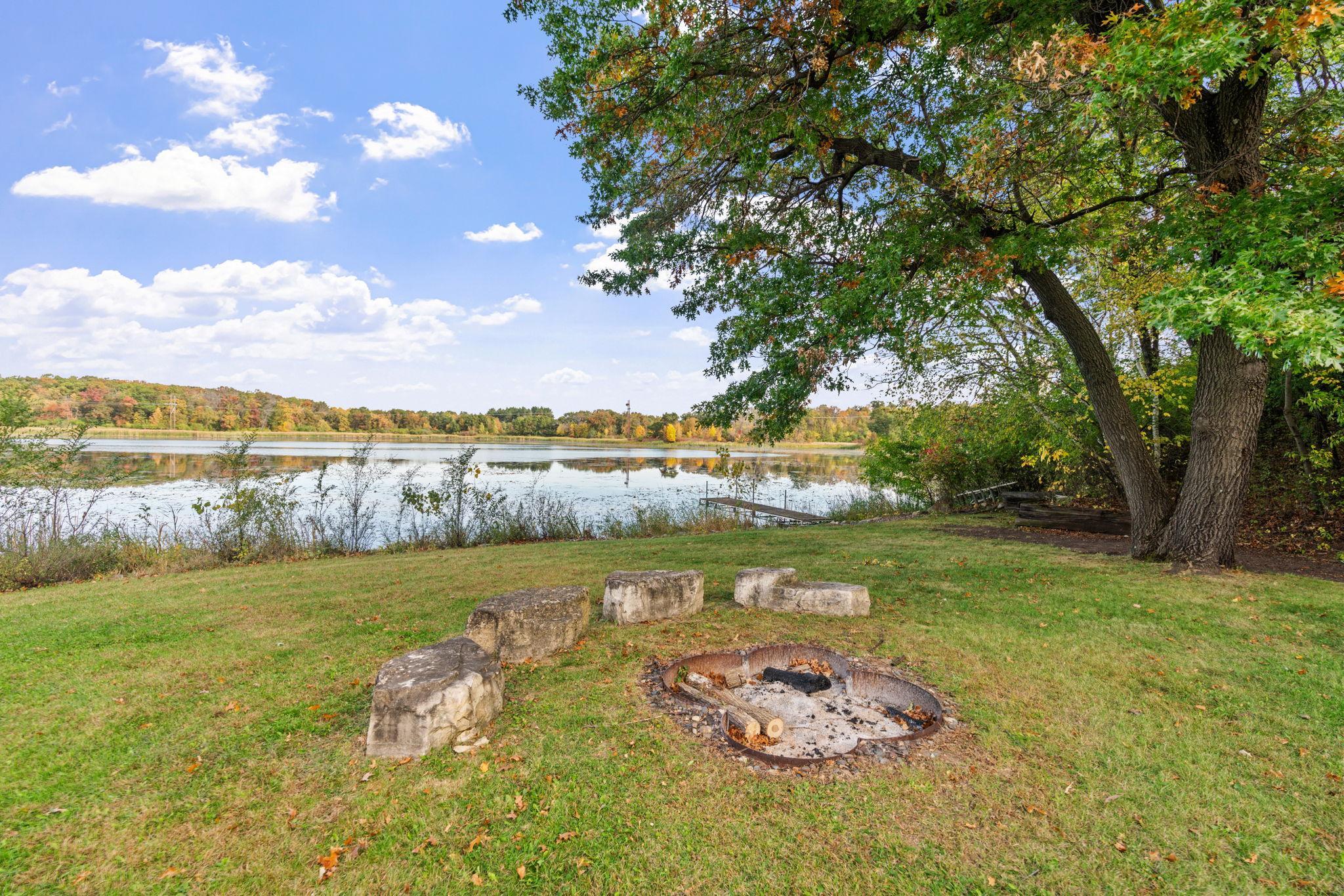Enjoy 2 full acres of privacy, mature trees, a dock, fire pit, patio, and peaceful views of the water.