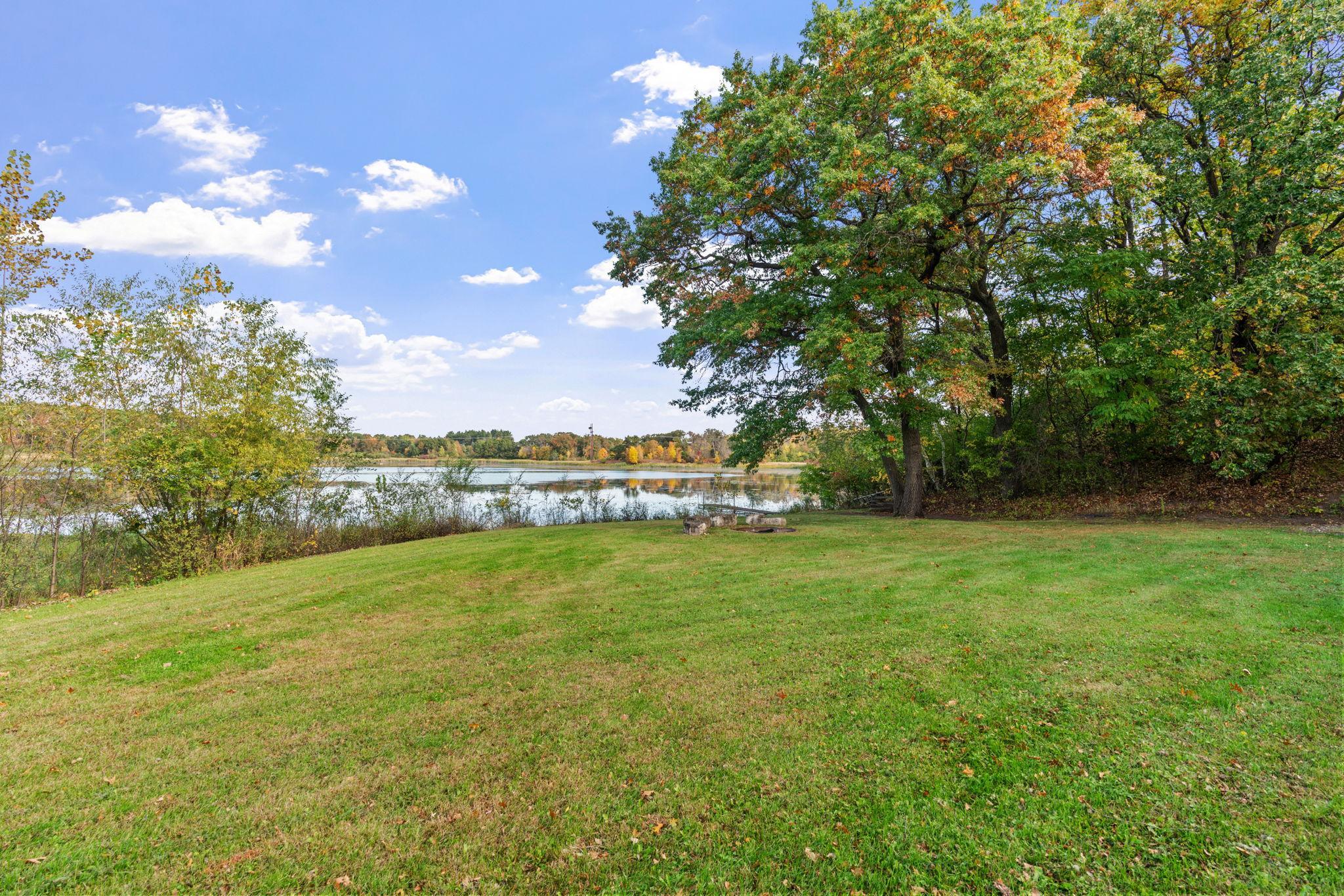 Enjoy 2 full acres of privacy, mature trees, a dock, fire pit, patio, and peaceful views of the water.
