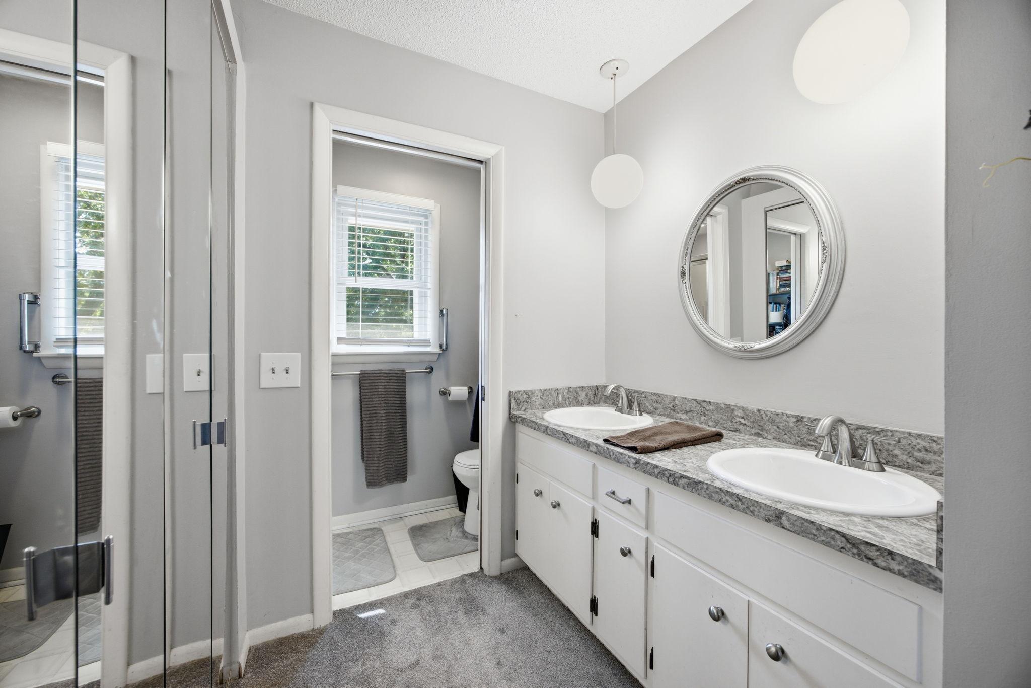 Private primary ensuite with double sinks, a private toilet & walk-in shower, and walk-in closets.
