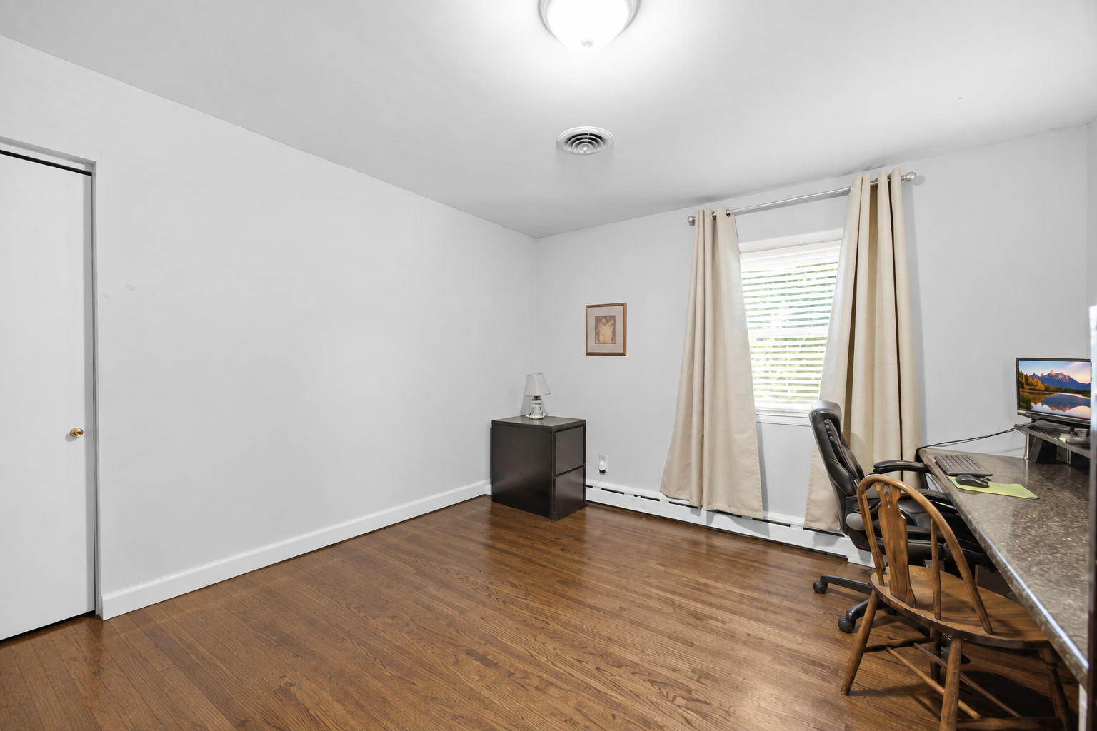 The third bedroom on the main level offers more hardwood floors and a built-in desk area perfect for those who work from home!