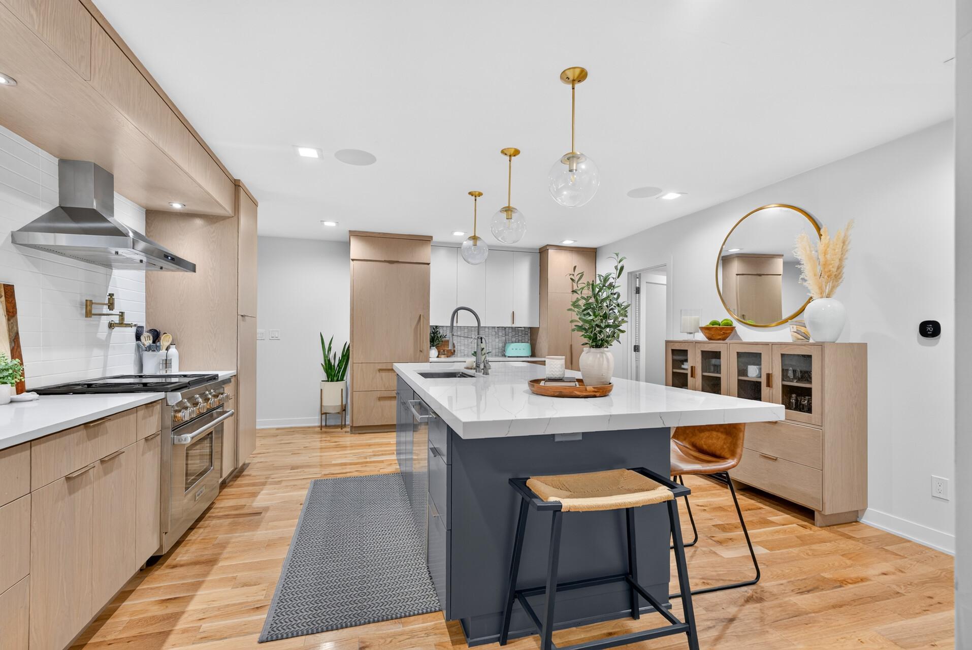 Large center island provides generous prep space and seating, surrounded by extensive cabinetry and counter space.