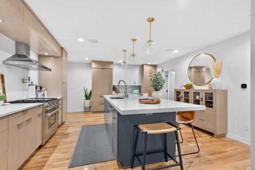 Large center island provides generous prep space and seating, surrounded by extensive cabinetry and counter space.