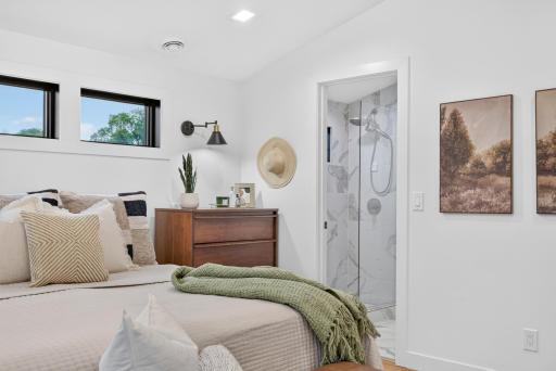 Primary bedroom includes direct access to the private ensuite bath with tiled walk-in shower.