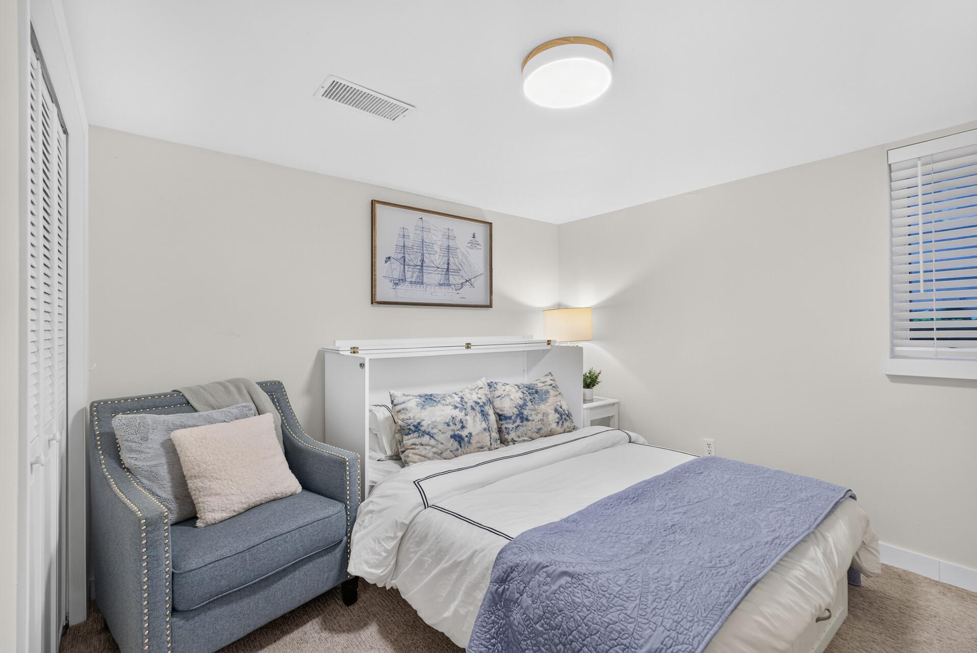 Lower-level bedroom with neutral finishes and ample closet space.