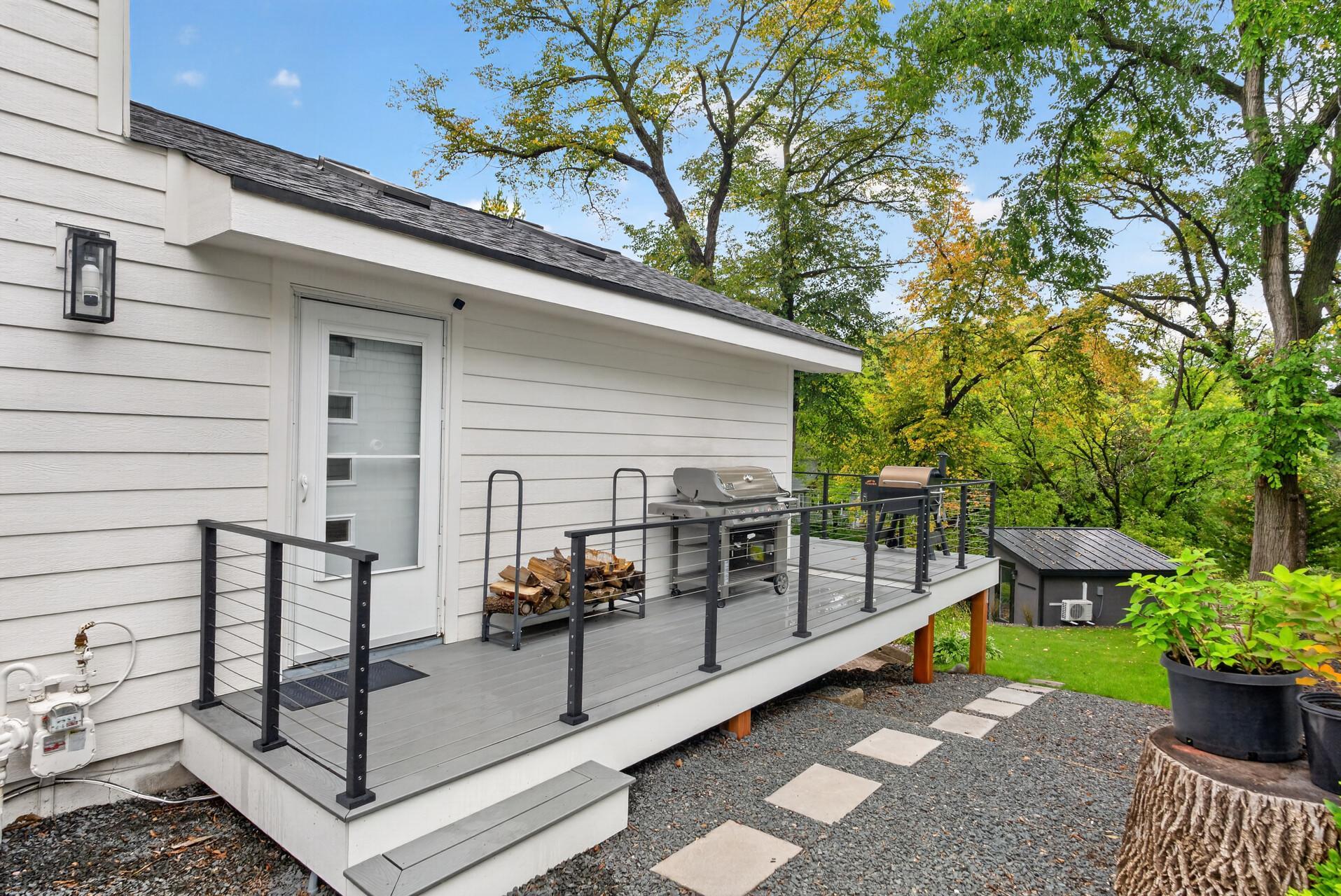 Wrap around deck with cable railing, offering space for grilling and outdoor entertaining.