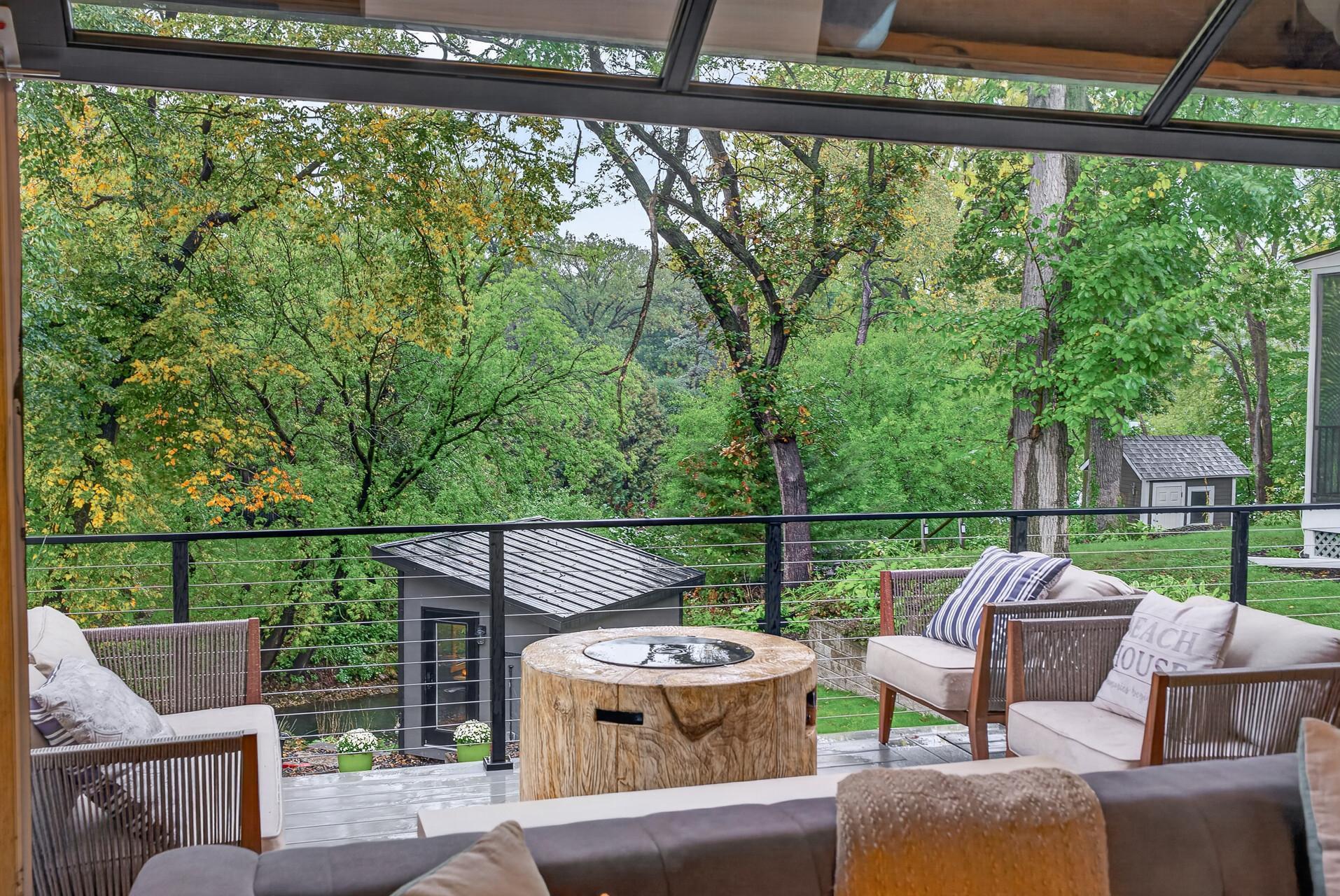 Glass garage door opens the great room to the elevated deck, creating a seamless indoor/outdoor living space with wooded backyard and channel views.