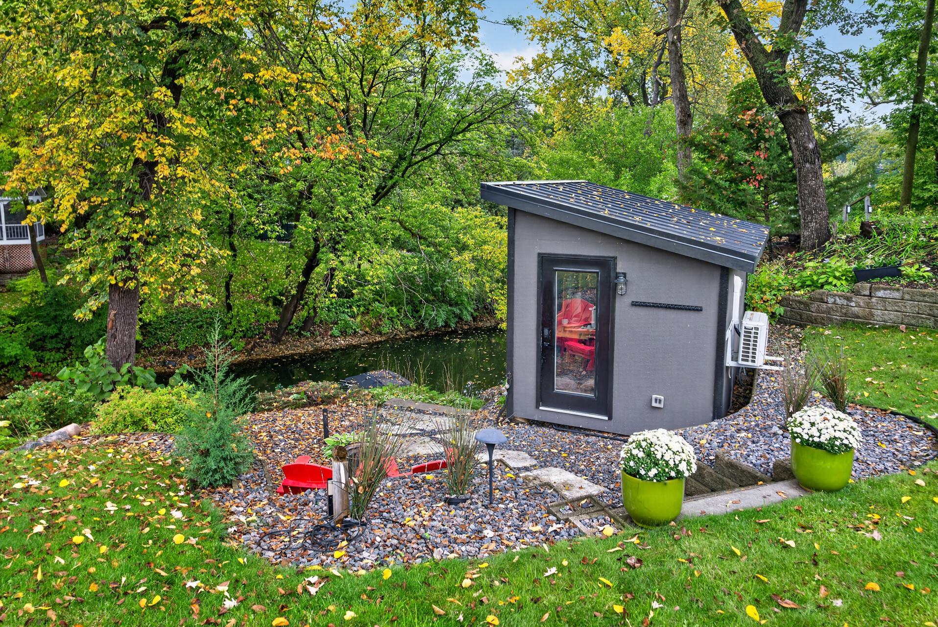 Lakeside studio overlooking the channel, offering a private and versatile space surrounded by mature trees and landscaped grounds.