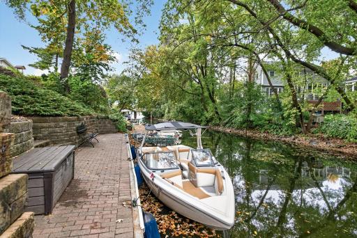 Private channel frontage with dock and brick-paver shoreline patio, providing convenient boat access and a peaceful waterfront setting.