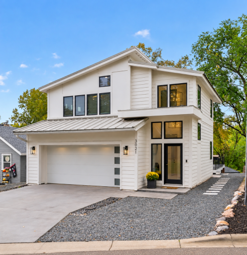 Updated exterior with LP SmartSide siding, contemporary black-trimmed windows, attached two-car garage and metal roof.
