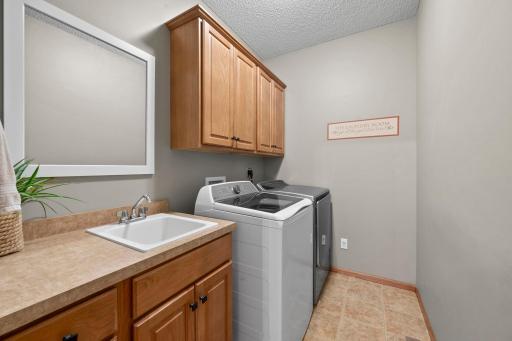 Convenient main level laundry features a utility sink and cabinetry for extra storage.