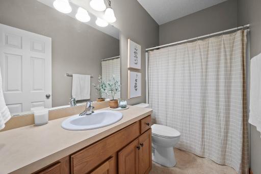 A full main level bathroom features a tub and shower combination and a spacious vanity.