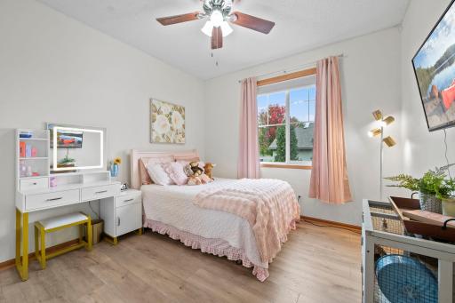 A bright second main level bedroom offers comfortable space with a large window and hardwood flooring.
