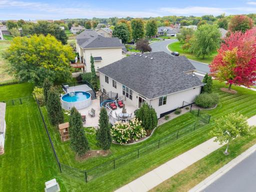 This aerial view showcases the backyard pool, deck, patio and established landscaping and fully fenced.