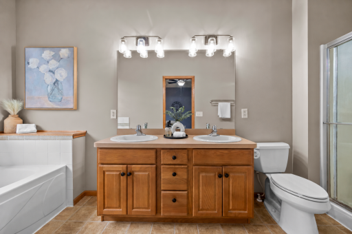 The private primary bathroom features a double sink vanity and separate tub and shower.