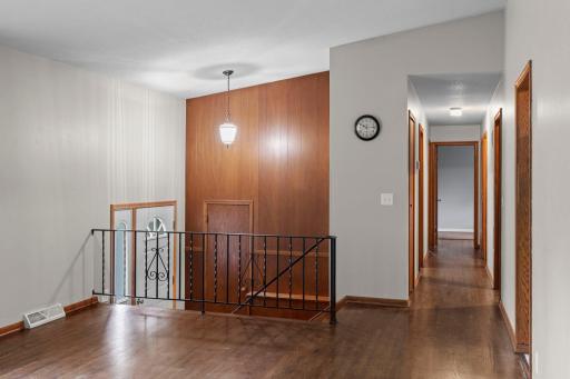 Warm wood paneling adds unique character and charm to the main level, while the hallway leads to all 4 main-level bedrooms