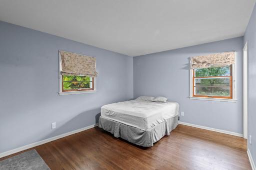 The main-level primary bedroom offers beautiful hardwood floors, multiple windows, and plenty of natural light