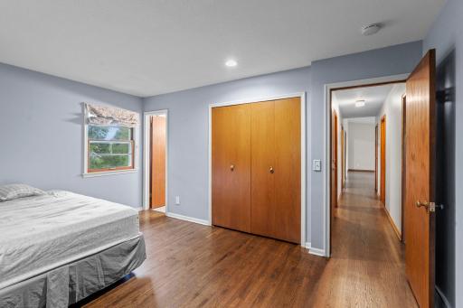 Another view of the primary bedroom highlights the closet space and convenient access to its private half bath