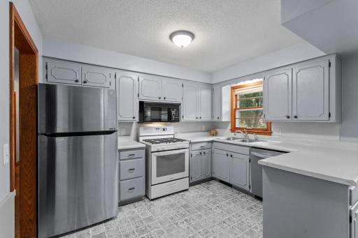 Ample cabinetry, generous workspace, a gas range and stainless steel appliances make this roomy kitchen functional and ready to enjoy