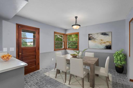 The informal dining area sits just off the kitchen, offering a bright and comfortable spot for meals with convenient access to the backyard and deck *This photo has been virtually staged