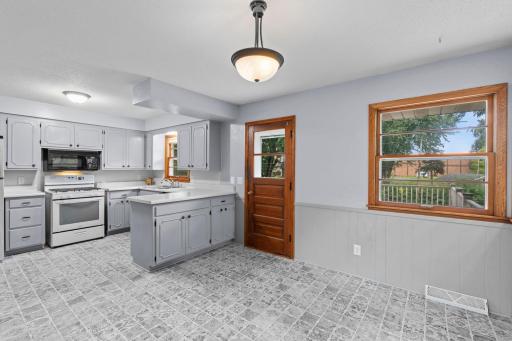 Bright and functional, the kitchen features plenty of workspace, crisp cabinetry, and a window overlooking the backyard