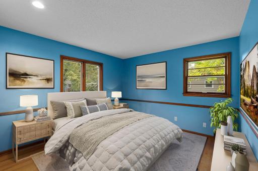 Main-level bedroom 2 offers hardwood floors, great natural light, and plenty of space to create a comfortable retreat *This photo has been virtually staged