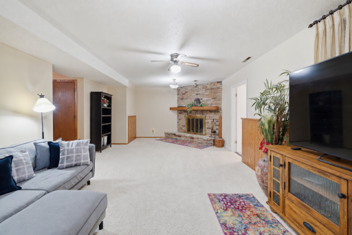 Family Room features ceiling fan, brick fireplace
