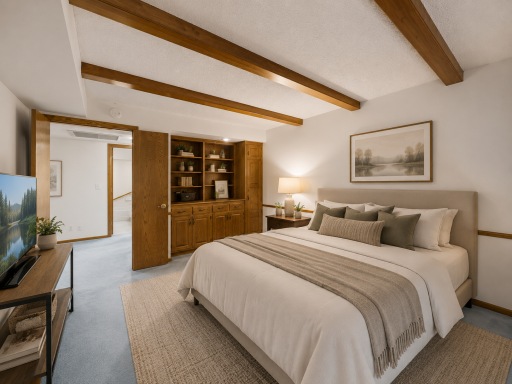 The second bedroom is equally generous in scale and versatility, ideal as a bedroom, home office, or additional living space. It includes plush carpeting, a full wall of built-in wood cabinetry and shelving, and charming wood beam ceiling accents.